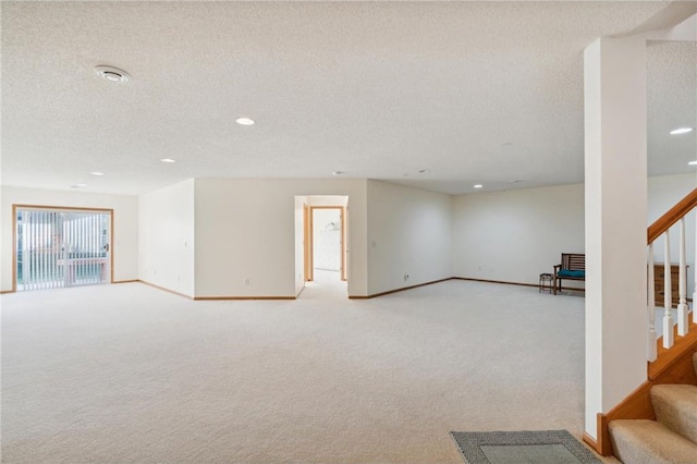 interior space featuring light colored carpet and a textured ceiling