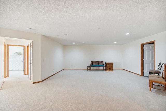 sitting room with light carpet and a textured ceiling