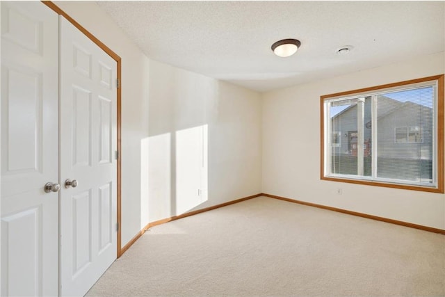 carpeted spare room featuring a textured ceiling