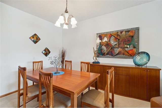 dining space with light carpet and a chandelier