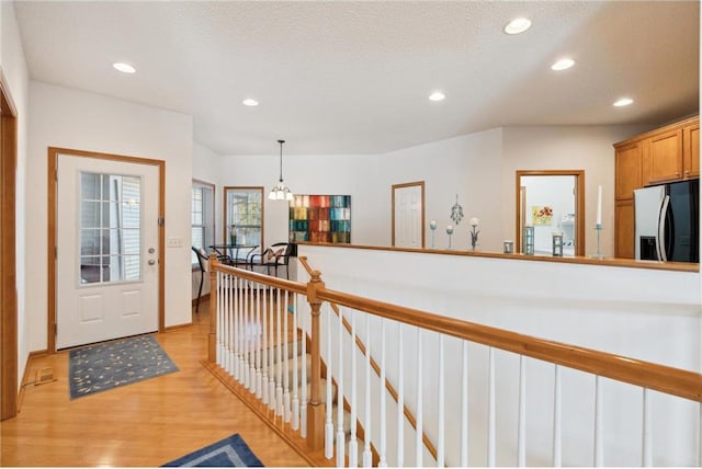 foyer with light hardwood / wood-style floors and a textured ceiling