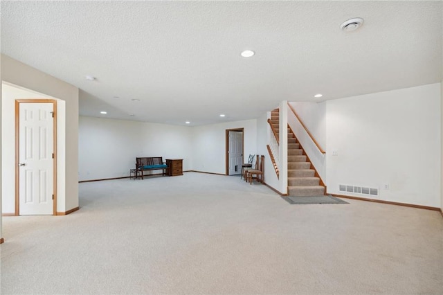 interior space with light carpet and a textured ceiling