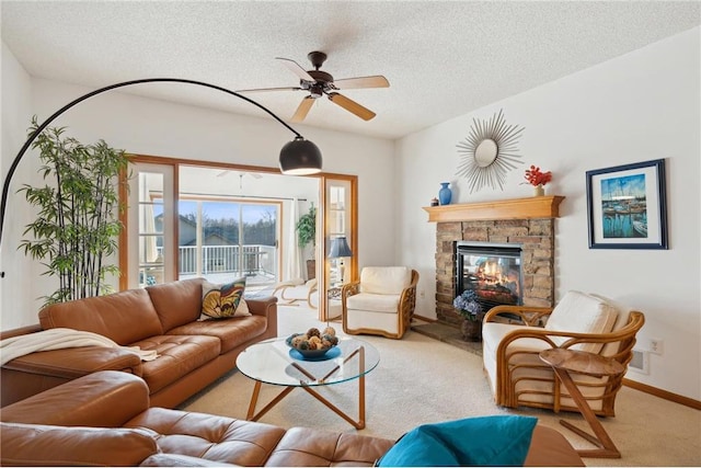 carpeted living room with ceiling fan, a textured ceiling, and a fireplace