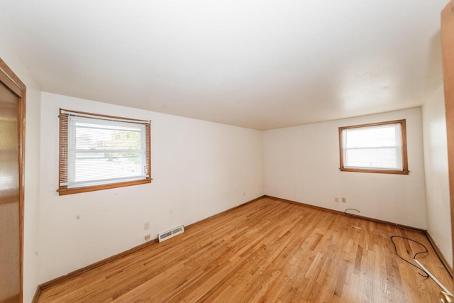 spare room featuring a healthy amount of sunlight and light hardwood / wood-style flooring