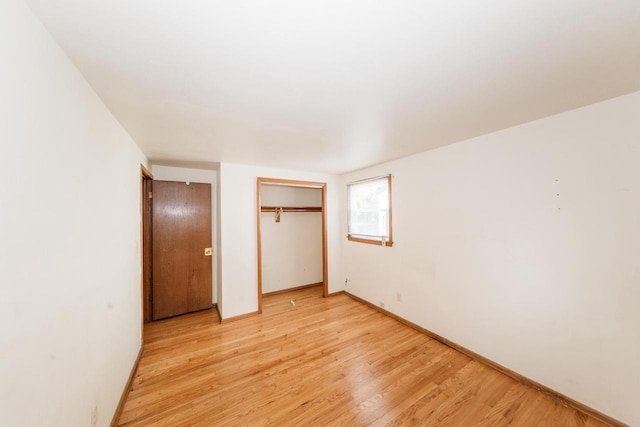 unfurnished bedroom featuring light wood-type flooring and a closet