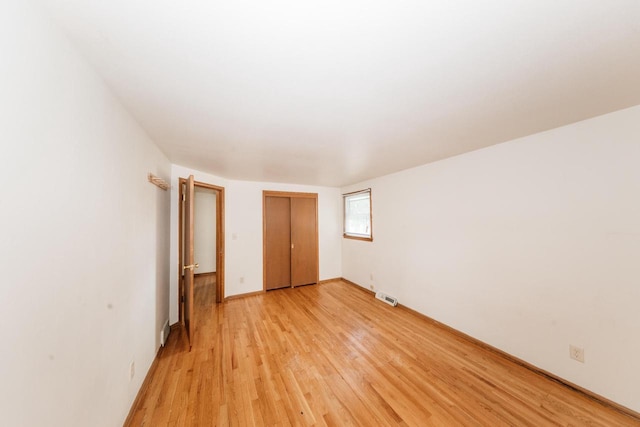 unfurnished bedroom featuring a closet and light hardwood / wood-style flooring