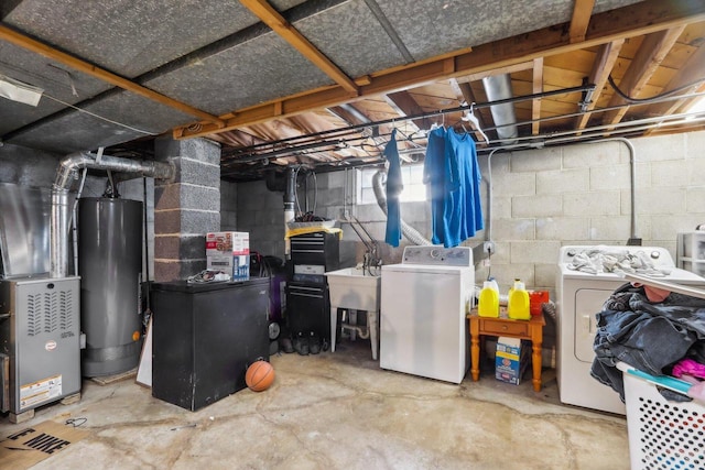 basement featuring washing machine and clothes dryer, sink, and gas water heater