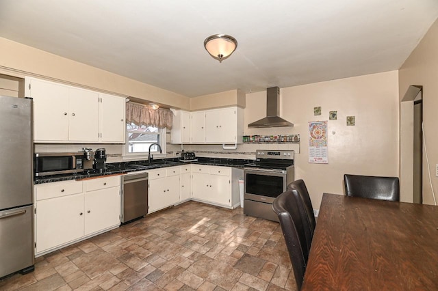 kitchen featuring wall chimney exhaust hood, appliances with stainless steel finishes, sink, and white cabinets