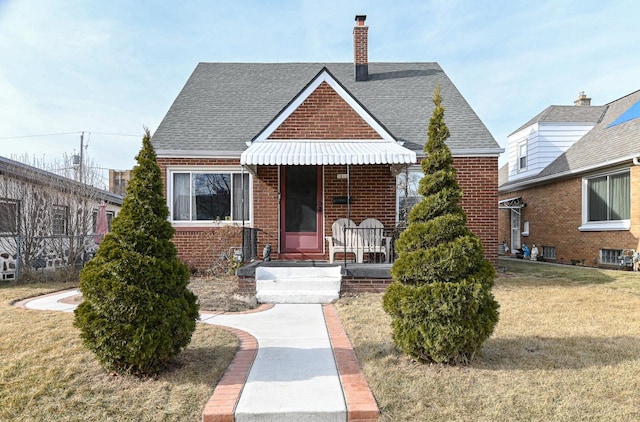 bungalow-style home featuring covered porch and a front lawn