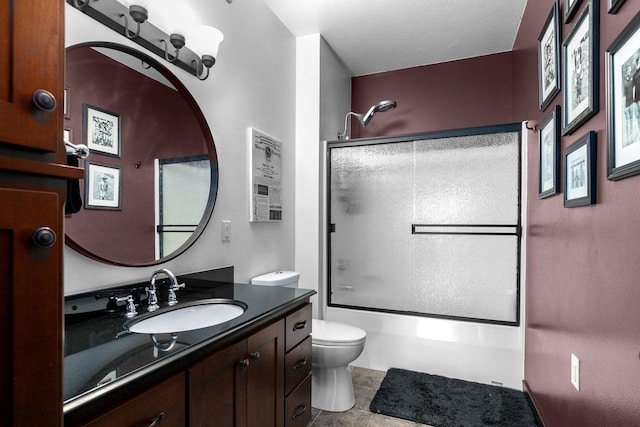 full bathroom with toilet, vanity, and shower / bath combination with glass door