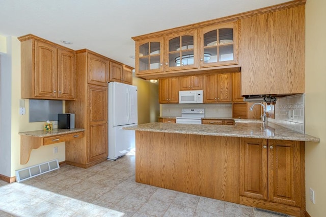 401 E Riverside Ave, Merrill, WI 54452 - kitchen featuring sink, kitchen peninsula, white appliances, light stone countertops, and decorative backsplash