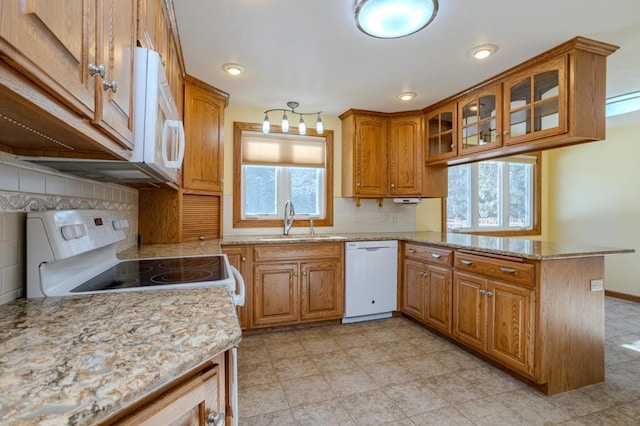 401 E Riverside Ave, Merrill, WI 54452 - kitchen featuring sink, light stone counters, kitchen peninsula, white appliances, and decorative backsplash