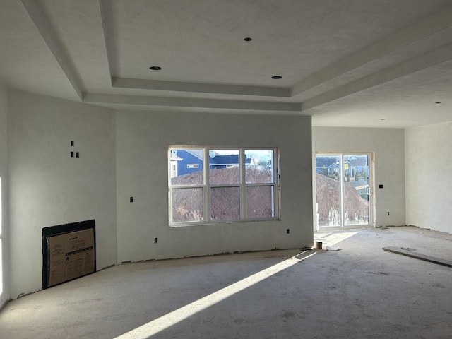 unfurnished living room featuring a tray ceiling