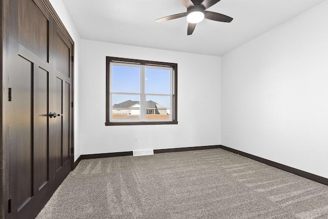 carpeted empty room featuring ceiling fan