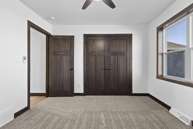 unfurnished bedroom with light carpet, a closet, and ceiling fan