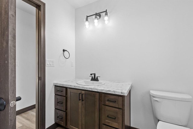 bathroom featuring vanity, toilet, and wood-type flooring