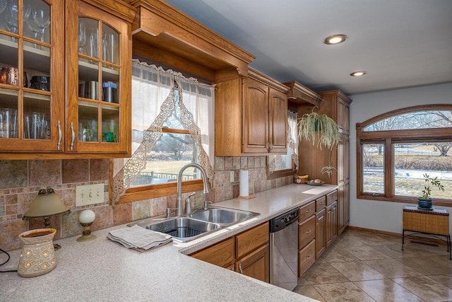 kitchen featuring sink, backsplash, light tile patterned floors, and dishwasher