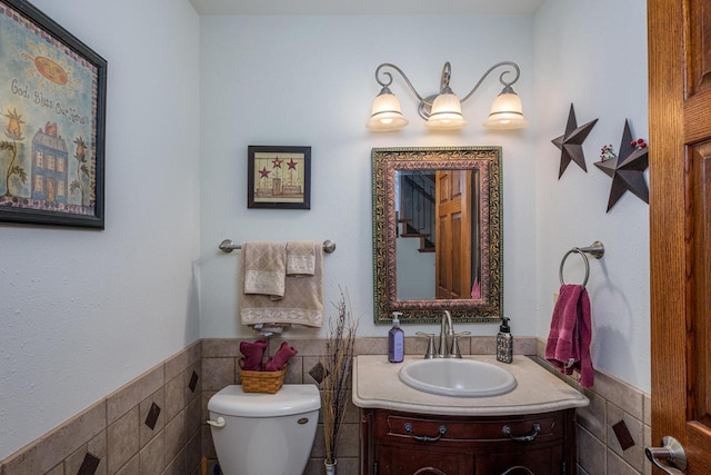 bathroom featuring vanity, toilet, and tile walls