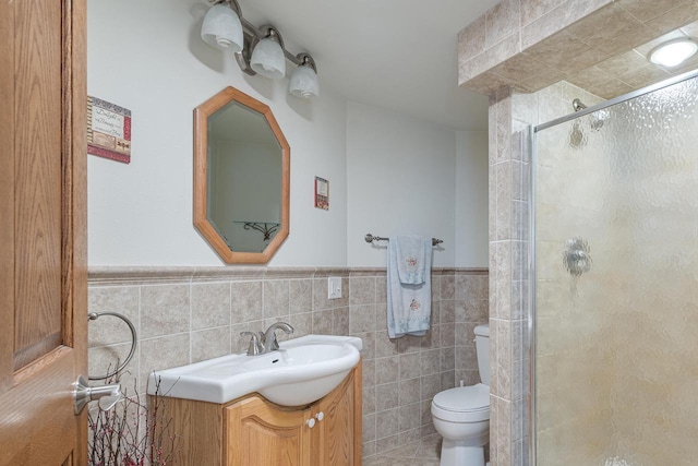 bathroom with vanity, toilet, tile walls, and walk in shower