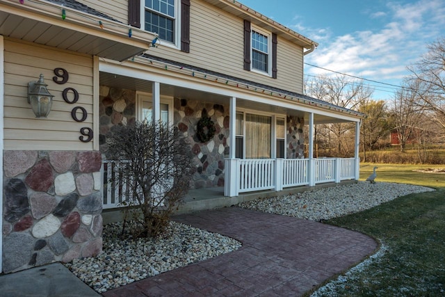 property entrance with a lawn and a porch