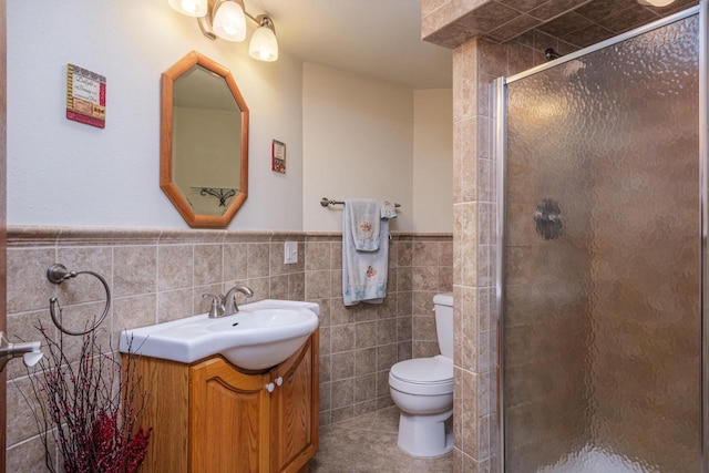 bathroom with toilet, an enclosed shower, tile walls, vanity, and tile patterned flooring