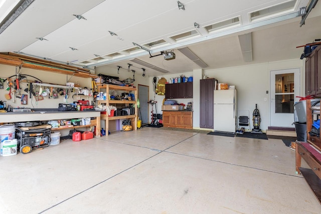 garage featuring a garage door opener, a workshop area, and white refrigerator