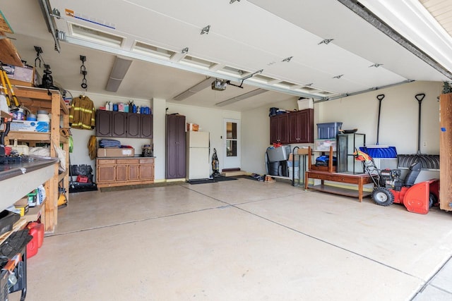 garage featuring a garage door opener, a workshop area, and white fridge