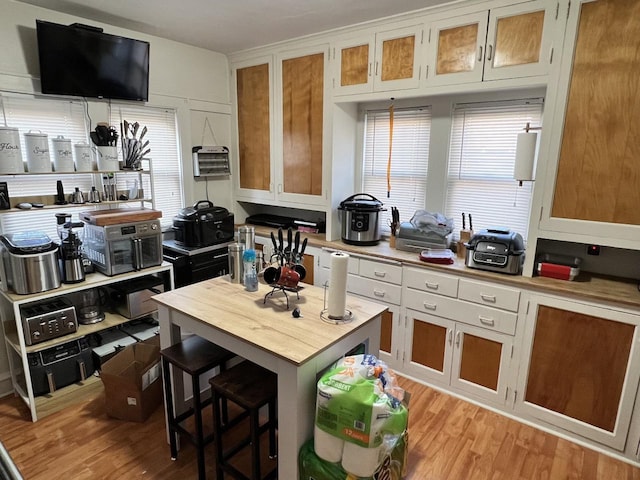 kitchen with a kitchen bar and light wood-type flooring