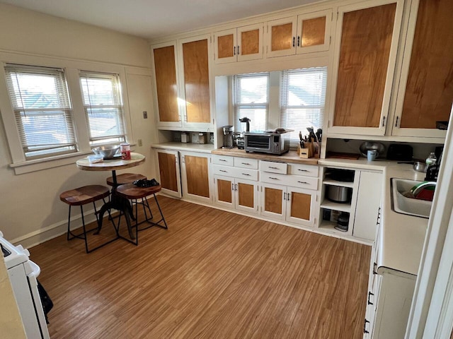 kitchen with sink, white electric stove, and light wood-type flooring