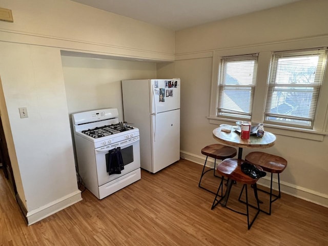 kitchen with white appliances and light wood-type flooring