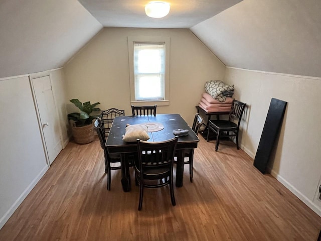 dining room with lofted ceiling and hardwood / wood-style floors