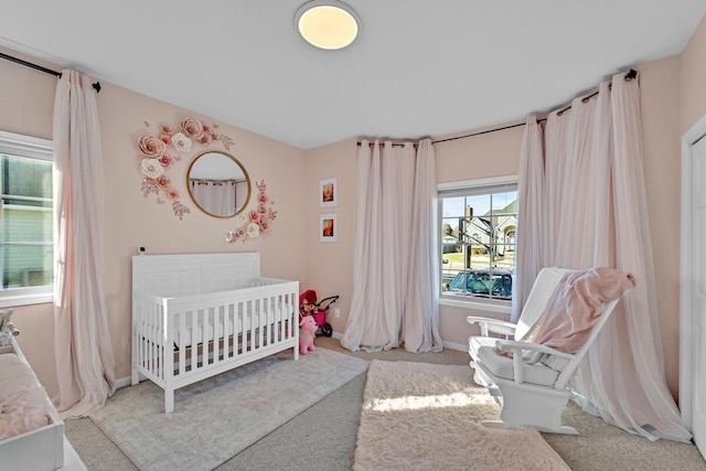 bedroom featuring light colored carpet and a crib