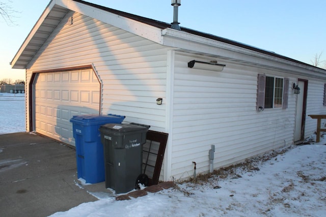 snow covered property with a garage