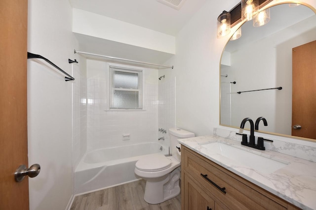 full bathroom with tiled shower / bath, wood-type flooring, vanity, and toilet