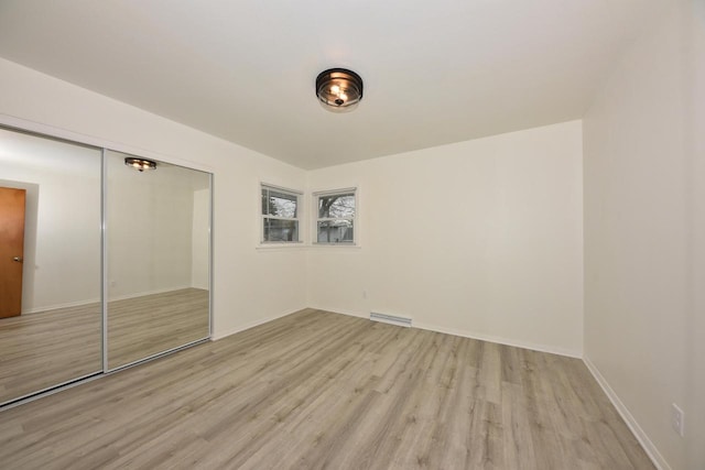 unfurnished bedroom with light hardwood / wood-style flooring and a closet