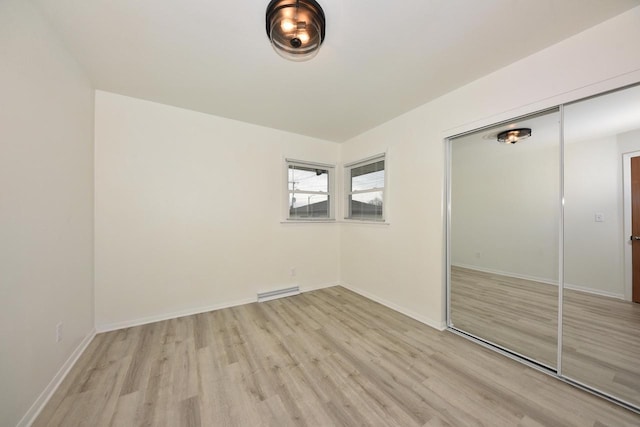 unfurnished bedroom featuring light hardwood / wood-style floors and a closet