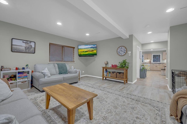 living room with beamed ceiling and light wood-type flooring