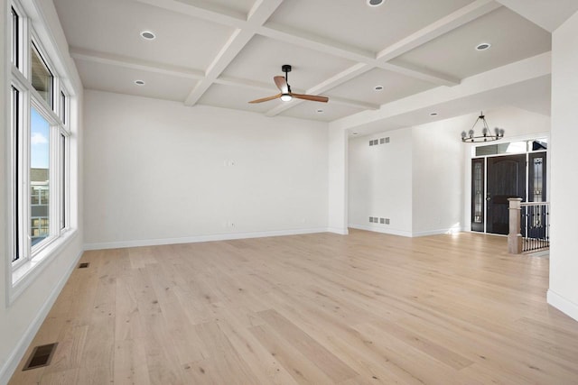 unfurnished living room featuring beamed ceiling, coffered ceiling, ceiling fan with notable chandelier, and light wood-type flooring