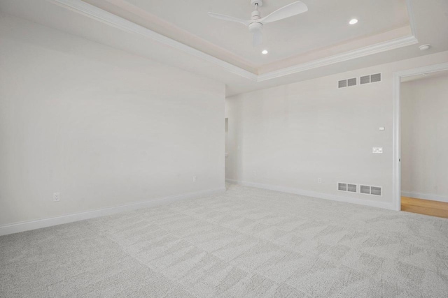 carpeted spare room featuring ornamental molding, a raised ceiling, and ceiling fan