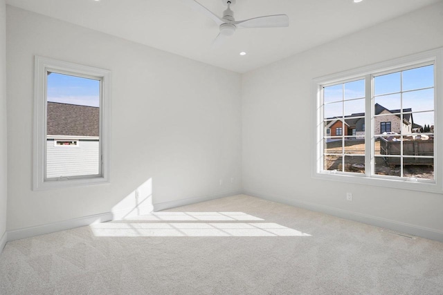 carpeted spare room featuring ceiling fan