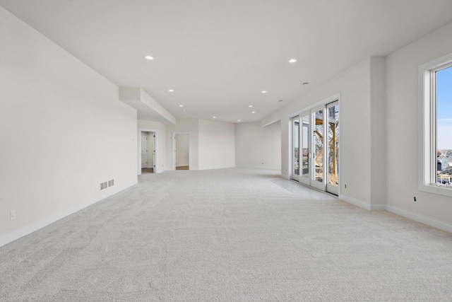 empty room with light colored carpet and plenty of natural light