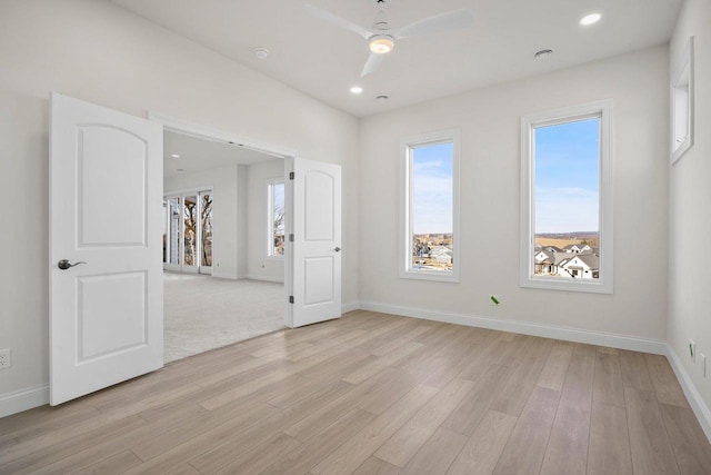 unfurnished room with ceiling fan and light hardwood / wood-style flooring