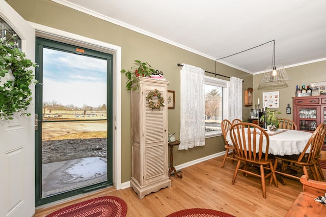 dining area with ornamental molding and light wood-type flooring