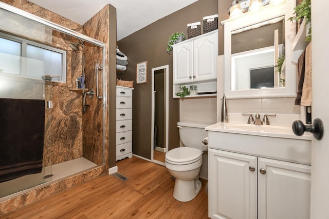 bathroom with vanity, wood-type flooring, a shower with door, and toilet