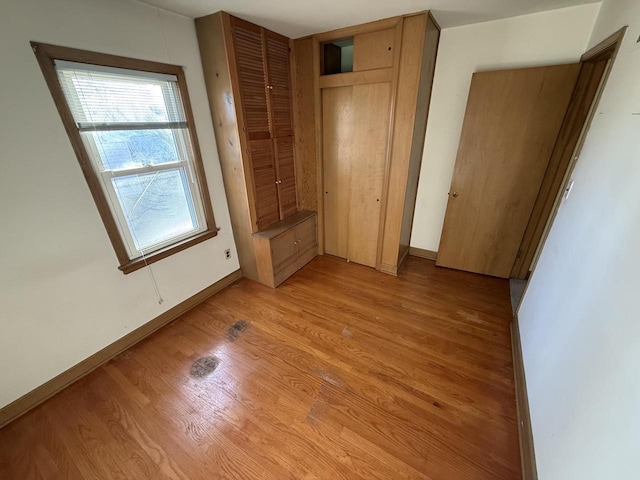 unfurnished bedroom featuring light hardwood / wood-style floors and a closet