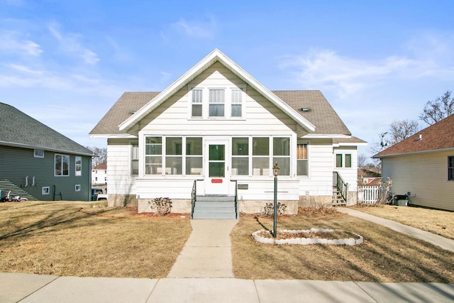 bungalow-style home featuring a front lawn and a sunroom