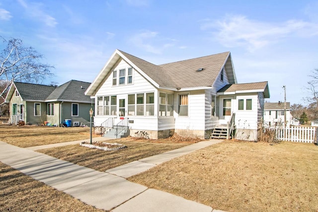 view of front of house featuring a front yard and a sunroom