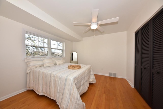 bedroom with light hardwood / wood-style floors, a closet, and ceiling fan