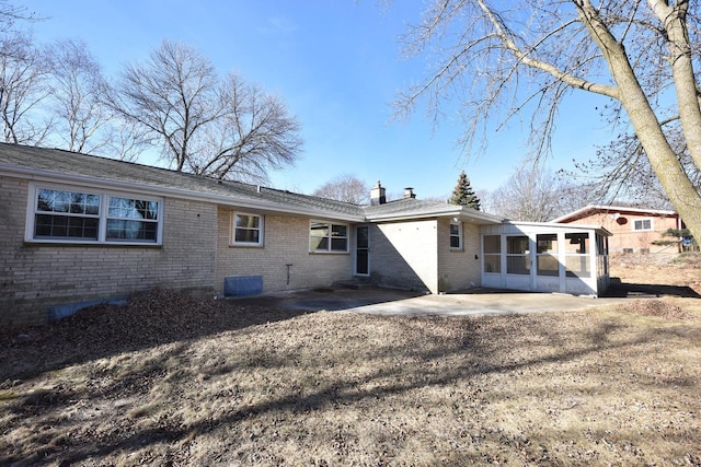 rear view of house with a patio area and a sunroom