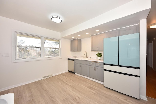 kitchen featuring refrigerator, dishwasher, sink, gray cabinetry, and light hardwood / wood-style floors